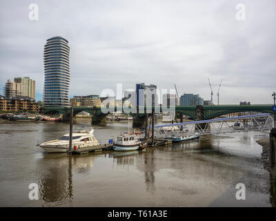 LONDON, Großbritannien - 23. JUNI 2018: Blick auf den Chelsea Harbour Pier mit dem Lombard Wharf Tower neben der Battersea Railway Bridge über die Themse Stockfoto