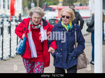 Paar älterer Frauen zu Fuß außerhalb der Verbindungsarme. Ältere weibliche Freunde mit den Armen verbunden. Senior Freundschaft. Stockfoto