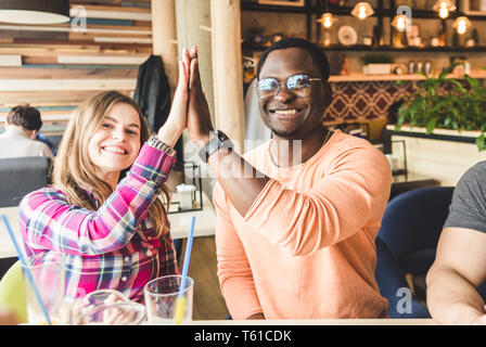 Junge attraktive Menschen im Cafe treffen. Freunden chatten, Spass haben, trinken Sie Cocktails und Essen Stockfoto