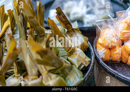 Lokale traditionelle thailändische Dessert; cassava Kuchen & gedämpft Mehl mit Kokos Füllung, auf der Bambus Platte, In der thailändischen Sprache bedeutet 888 Kuchen und steame Stockfoto