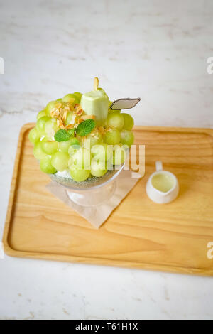 Grüne melone Kugel Form angeordnet sind auf der Oberseite des bingsu (koreanische Eis Stil) und mit grünem Tee Eis und minzeblatt auf dem Holz pla eingerichtet Stockfoto