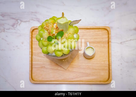 Grüne melone Kugel Form angeordnet sind auf der Oberseite des bingsu (koreanische Eis Stil) und mit grünem Tee Eis und minzeblatt auf dem Holz pla eingerichtet Stockfoto