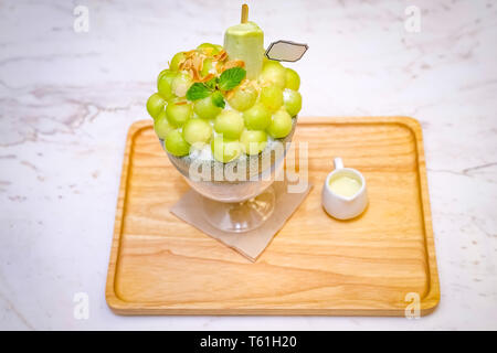 Grüne melone Kugel Form angeordnet sind auf der Oberseite des bingsu (koreanische Eis Stil) und mit grünem Tee Eis und minzeblatt auf dem Holz pla eingerichtet Stockfoto