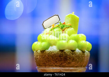 Grüne melone Kugel Form angeordnet sind auf der Oberseite des bingsu (koreanische Eis Stil) und mit grünem Tee Eis und minzeblatt auf dem Holz pla eingerichtet Stockfoto