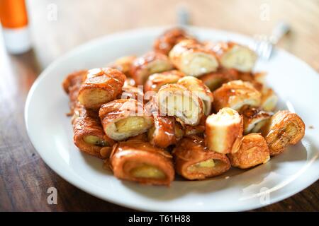 Eine Banane Snack und Mandeln in Honig bereit zu essen, und spitze Kondensmilch Gezuckert vor dem Essen. Stockfoto