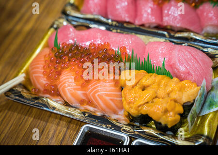 Sushi Lachs und andere Sushi sind in Schaum auf dem Tisch bereit an: Kuromon Fischmarkt, Osaka, Japan angeordnet Stockfoto