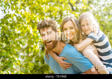 Starke Mann seine Familie Unterstützung durch die Ehefrau und die Tochter piggyback Stockfoto