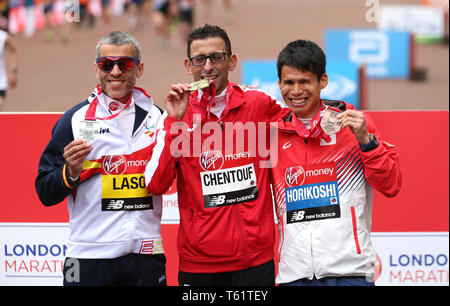 Marokko El Amin Chentouf (Mitte) feiert den Gewinn der WPA Marathon neben dem Zweitplatzierten Spanien Alberto Suarez Laso (links) und vierten platziert Japans Tadashi Horikoshi (rechts) während der 2019 Virgin Money London Marathon. Stockfoto