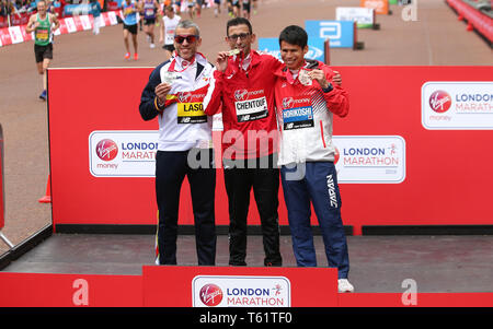 Marokko El Amin Chentouf (Mitte) feiert den Gewinn der WPA Marathon neben dem Zweitplatzierten Spanien Alberto Suarez Laso (links) und vierten platziert Japans Tadashi Horikoshi (rechts) während der 2019 Virgin Money London Marathon. Stockfoto