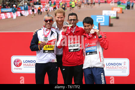 Der Herzog von Sussex posiert für ein Foto mit der marokkanischen El Amin Chentouf (Mitte) feiert den Gewinn der WPA Marathon neben dem Zweitplatzierten Spanien Alberto Suarez Laso (links) und dem vierten Japan Tadashi Horikoshi (rechts) während der 2019 Virgin Money London Marathon platziert. Stockfoto