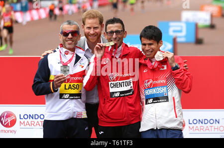 Der Herzog von Sussex posiert für ein Foto mit der marokkanischen El Amin Chentouf (Mitte) feiert den Gewinn der WPA Marathon neben dem Zweitplatzierten Spanien Alberto Suarez Laso (links) und dem vierten Japan Tadashi Horikoshi (rechts) während der 2019 Virgin Money London Marathon platziert. Stockfoto