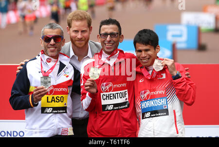 Der Herzog von Sussex posiert für ein Foto mit der marokkanischen El Amin Chentouf (Mitte) feiert den Gewinn der WPA Marathon neben dem Zweitplatzierten Spanien Alberto Suarez Laso (links) und dem vierten Japan Tadashi Horikoshi (rechts) während der 2019 Virgin Money London Marathon platziert. Stockfoto