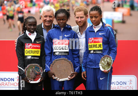 Der Herzog von Sussex posiert für ein Foto mit Kenias Brigid Kosgei (Mitte) nach Erhalt die Trophäe für den Sieg der Frauen London Marathon neben dem Zweitplatzierten Kenias Vivian Cheruiyot (rechts) und Dritte platziert Äthiopiens Roza Dereje (links) Während der 2019 Virgin Money London Marathon. Stockfoto