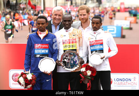 Der Herzog von Sussex posiert für ein Foto mit Kenias Eliud Kipchoge (Mitte) nach Erhalt der Trophäe für das Gewinnen der Männer Marathon neben dem Zweitplatzierten Äthiopiens Mosinet Geremew (links) und dem dritten Platz in Äthiopien Maultier Washihun (rechts) während der 2019 Virgin Money London Marathon. Stockfoto