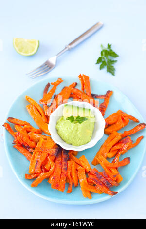 Gebackene süsse Kartoffel Pommes und Avocado dip Stockfoto