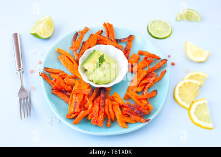 Gebackene süsse Kartoffel Pommes und Avocado dip Stockfoto