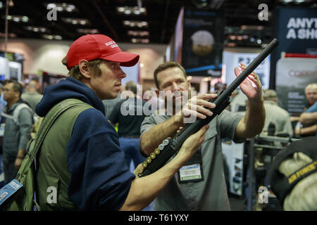 Indianapolis, Indiana, Großbritannien. 27 Apr, 2019. Eine NRB Mitglied und Trump Unterstützer trägt eine MAGA hat sich mit einer Schrotflinte in den dritten Tag der National Rifle Association. Quelle: Jeremy Hogan/SOPA Images/ZUMA Draht/Alamy leben Nachrichten Stockfoto