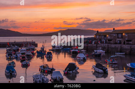 Lyme Regis, Dorset, Großbritannien. 28. April 2019. UK Wetter: Glorious sunrise im Cobb in Lyme Regis. Der Himmel glüht mit leuchtenden Farben im Cobb Hafen am Sonntag Morgen. Credit: Celia McMahon/Alamy leben Nachrichten Stockfoto