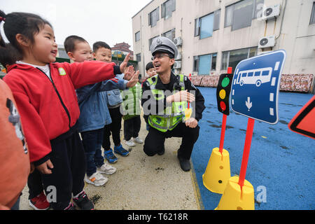 Changxing, der chinesischen Provinz Zhejiang. 28 Apr, 2019. Ein Polizist lehrt Kindern Verkehrszeichen in einem Kindergarten in Lijiaxiang Township von changxing in der Grafschaft zu erkennen, der ostchinesischen Provinz Zhejiang, 28. April 2019. Changxing Verkehr Polizei führte einen Outreach Programm zur Straßenverkehrssicherheit in einem Kindergarten, so dass Kinder über Verkehr Regeln lernen kann. Credit: Xu Yu/Xinhua/Alamy leben Nachrichten Stockfoto