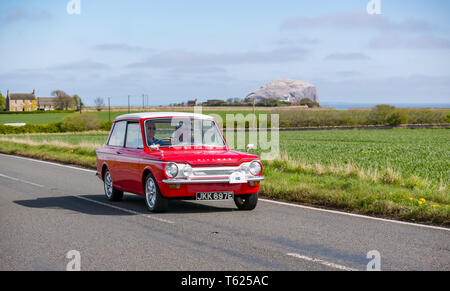 Im Osten der britischen Region Lothian. 28. April 2019. Oldtimer Tour: North Berwick Rotary Club hält seine 3. Rallye mit 65 klassischen Autos eingetragen. Die Rallye Route ist von East Lothian und zurück durch die Scottish Borders, Geld für lokale Wohltätigkeitsorganisationen. Ein rotes 1967 875 cc Hillman Imp vorbeifahren Bass Rock auf dem Firth-of-Forth Küste Stockfoto
