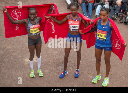 London, Großbritannien. 28. April 2019. Der London Marathon Rennen Ende auf der Mall in Westminster. Bild: Sieger Brigid Kosgei (KEN) mit Vivian Cheruiyot (2.) und Roza Dereje (3.). Credit: Malcolm Park/Alamy Leben Nachrichten. Stockfoto