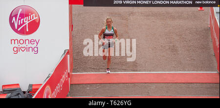 London, Großbritannien. 28. April 2019. Der London Marathon Rennen Ende auf der Mall in Westminster. Bild: Emily Sisson (USA) kommt über die Ziellinie in der Elite der Frauen beim Marathon in 2:23:08. Credit: Malcolm Park/Alamy Leben Nachrichten. Stockfoto