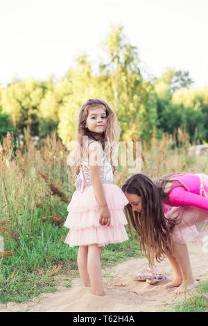 Porträt von zwei glücklichen kleinen Mädchen Spaß und Spielen mit Sand an sonnigen Sommertag Stockfoto