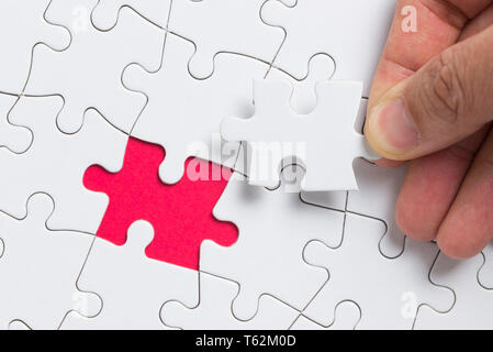 Hand das letzte Stück weißes Puzzle für Business Konzept und Inhalt Hintergrund Stockfoto