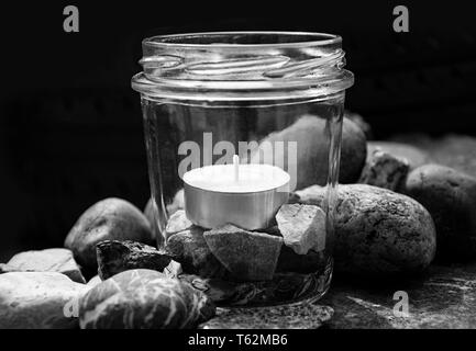 Schwarze und Weiße tee Kerze Glas Steine center dunklen Hintergrund   durch jziprian Stockfoto