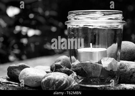 Schwarze und Weiße tee Kerze Glas Steine Rechts Gräser Hintergrund   durch jziprian Stockfoto