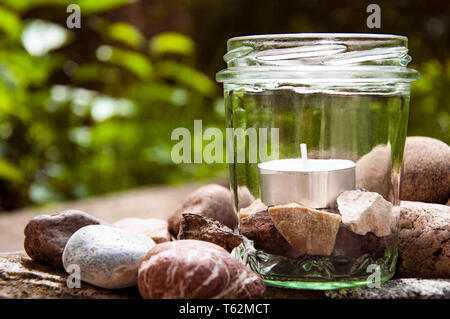 White tee Kerze Glas Steine Rechts Gräser Hintergrund   durch jziprian Stockfoto