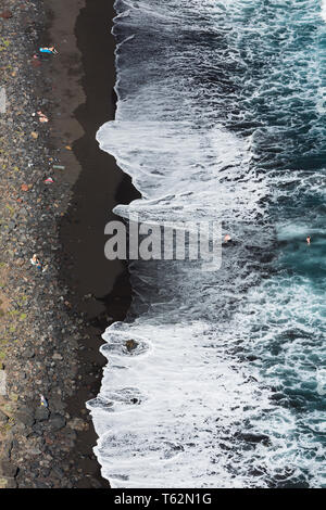 Touristen genießen hohe Wellen am Playa de Nogales Strand in La Palma, Spanien. Hohen winkel Blick von einem Aussichtspunkt auf dem Felsen. Stockfoto