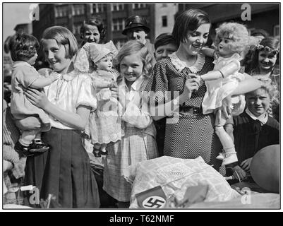 Vintage Nazi Propaganda Bild einer Gruppe von Deutschen Mädchen mit Puppen und Kinderwagen, mit hakenkreuzfahne im Vordergrund. Sie bereiten sich auf die Mütter und Kinder Tag Prozession in Berlin Deutschland 1934 zu gehen Stockfoto