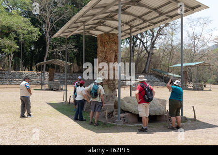 Copan Touristen - eine Gruppe von westlichen Touristen auf eine geführte Tour durch die alten Maya Copan Website zu einem Stein; Copan, Honduras Mittelamerika Stockfoto
