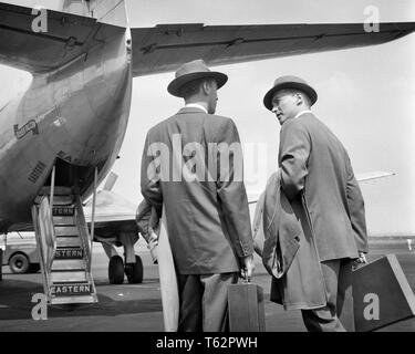 1950er Jahre zwei Geschäftsleute sprechen auf Asphalt ZU GEBEN SIE HINTERTÜREN DER EASTERN AIRLINES FLUGZEUG-a 3124 DEB001 HARS MÄNNER LEITENDE TRANSPORT B&W VERKAUF VON FLUGZEUGEN OSTEUROPA REISE ASPHALT RÜCKANSICHT AIRLINES AVIATION REISEN BOSSE DEB001 RÜCKANSICHT DER KOMMERZIELLEN LUFTFAHRT EIN MANAGER Mitte - Mitte - erwachsenen Mann VERKÄUFER REISENDEN REISENDE fast schwarzer und weißer KAUKASISCHEN ETHNIE ALTMODISCH Stockfoto