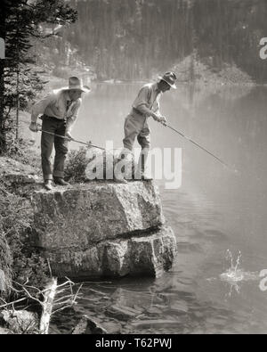 1920er zwei Männer stehen auf felsigen Ufer angeln im See O'Hara BRITISH COLUMBIA KANADA - Eine 3134 HAR 001 HARS SKILL AKTIVITÄT AMUSEMENT FELSIGE ABENTEUER HOBBY REISE INTERESSE GETAWAY HOBBYS WISSEN ZEITVERTREIB VERGNÜGEN COLUMBIA FERIEN CONNECTION GUIDE STILVOLLE ANGELSEE O'Hara Mitte - Mitte - erwachsenen Mann ENTSPANNUNG FERIEN AMATEUR SCHWARZ UND WEISS BOULDER BRITISH COLUMBIA KAUKASISCHEN ETHNIE GENUSS HAR 001 ALTMODISCH Stockfoto