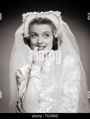 1950 Porträt der Braut mit COY SCHÜCHTERN BESCHEIDEN ZÖGERLICH UNSICHER LUSTIGE MIMIK SUCHEN BEISEITE BEISSEN FINGERNAGEL-b10431 DEB001 HARS B&W BRAUT BRÄUTE WAHL DER BEISSENDEN ZÖGERLICH UNSICHER KONZEPTIONELLE SCHÜCHTERN STILVOLLE DEB001 OLEGS GESICHTSAUSDRUCK FINGERNAGEL AUF DER SUCHE NEBEN JUNGEN ERWACHSENEN FRAU SCHWARZ UND WEISS KAUKASISCHEN ETHNIE BESCHEIDENEN ALTMODISCH Stockfoto