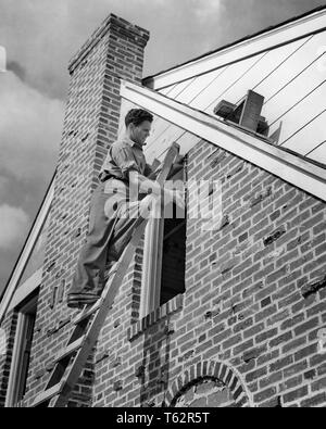 1940 Arbeiter auf TRITTLEITER GERADE EIN NEUES FENSTER AUF BRICK HOUSE - b10977 HAR 001 HARS WOHN- Männer gefährdete Gebäude BERUF VERTRAUEN B&W SKILL BERUF FÄHIGKEITEN EIGENSCHAFT STÄRKE KARRIERE STOSSFÄNGER VERSCHRAUBUNG WISSEN BESCHÄFTIGUNG DER ARBEITSKRÄFTE WOHNUNGEN BERUFE IMMOBILIEN KONZEPTIONELLEN STRUKTUREN RESIDENCE GEBÄUDE MITARBEITER TRITTLEITER junger erwachsener Mann SCHWARZ UND WEISS KAUKASISCHEN ETHNIE HAR 001 INSTALLATION ARBEITENDEN ALTMODISCH Stockfoto