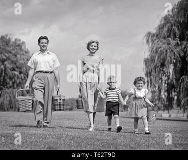 1950 s FAMILIE ZU FUSS IN RICHTUNG AUF KAMERA SOHN Hand in Hand mit Mutter und Schwester, Vater, PICKNICKKORB UND KÜHLER-c 5616 HAR 001 HARS PAAR 4 SUBURBAN MÜTTER ALTE ZEIT BESETZT NOSTALGIE BRUDER OLD FASHION SCHWESTER 1 JUGENDLICHE BALANCE TEAMARBEIT SÖHNE GERNE FAMILIEN FREUDE LIFESTYLE FRAUEN VERHEIRATETE BRÜDER LÄNDLICHEN EHEPARTNER EHEMÄNNER GESUNDHEIT LEBEN ZU HAUSE KOPIEREN RAUM VOLLER LÄNGE DAMEN FITNESS TÖCHTER PERSONEN MÄNNER GESCHWISTER SPIRITUALITÄT VERTRAUEN SCHWESTERN VÄTER B&W PARTNER AUGENKONTAKT WEITWINKEL GLÜCK FREUNDLICHE STÄRKE VATIS ERHOLUNG GESCHWISTER LÄCHELT VERBINDUNG KONZEPTIONELLER ESCAPE Stockfoto