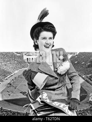 1940er lächelnd brünette Frau COED ALUMNA TRAGEN HOMECOMING CORSAGE HOLDING MEGAPHON COLLEGE PENNANT STADION HINTERGRUND-f 1689 HAR 001 HARS GERNE FREUDE LIFESTYLE FEIER FRAUEN IM STUDIO SHOT VERANSTALTUNG GESUNDHEIT KOPIE RAUM MIT HALBER LÄNGE DAMEN PERSONEN B&W BRUNETTE GLÜCK FRÖHLICH STILE COMPOSITE AUFREGUNG MOM ERHOLUNG CHRYSANTHEME STOLZ WIMPEL LÄCHELT CORSAGE HOMECOMING FREUDIGE STILVOLLE BOOSTER ALUMNI DIE TEILNAHME AN COED MODEN FUSSBALL JUNGEN ERWACHSENEN FRAU AMERICAN FOOTBALL SCHWARZ UND WEISS KAUKASISCHEN ETHNIE HAR 001 ALTMODISCH Stockfoto