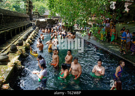 Touristen und Anbeter Reinigung bei Tampak Siring, den Heiligen Quellwasser Tempel in der Nähe von Ubud auf Bali, Indonesien Stockfoto