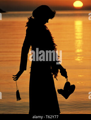 1970 s ANONYME SILHOUETTE PROFIL DER JUNGEN FRAU MIT FEDERBOA DURCHFÜHRUNG ABEND HANDTASCHE UND SCHUHE ZU FUSS DURCH MOONLIT WATER-ks 15760 PHT 001 HARS REFLEXION ABSTRAKTE FREUDE LIFESTYLE FEIER FRAUEN MOODY IN VOLLER LÄNGE DAMEN PERSONEN SPIRITUALITÄT UNRUHIGEN MORGEN TRAUER TRÄUME GLÜCK SILHOUETTE und Stolz von der Laune bummeln VERBINDUNG KONZEPTIONELLER GLUM SUNRISE PHANTASIE MOONLIGHT STILVOLLE ANONYME FEDERBOA WACHSTUM MISERABEL MOONLIT JUNGEN ERWACHSENEN FRAU NIEDERGESCHLAGEN ALTMODISCH Stockfoto