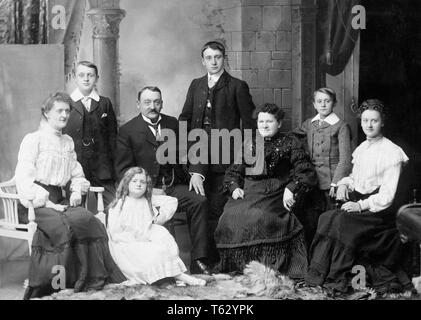 1800s 1890s 1900s DÜSTER WENDE DES 20. JAHRHUNDERTS FAMILY PORTRAIT erweiterte Familie Mama, Papa, Kinder, andere suchen bei CAMERA-o6383 HAR 001 HARS GROSSMUTTER ALTE ZEIT NOSTALGIE BRUDER OLD FASHION SCHWESTER JUVENILE GESICHTSBEHANDLUNG SÖHNE GROSSELTERN FAMILIEN LIFESTYLE GESCHICHTE FRAUEN VERHEIRATET GROSSELTERN BROTHERS STUDIO SHOT EHEPARTNER ERWEITERTE EHEMÄNNER GROWNUP HOME LEBEN IN VOLLER LÄNGE TÖCHTER ERWACHSEN männliche Teenager jungen Geschwister Schwestern älterer Erwachsener Ausdrücke Väter im mittleren Alter 1800s B&W Mann mittleren Alters AUGENKONTAKT SENIOR FRAU ERFOLG STÄRKE, UM SICH DES 20. JAHRHUNDERTS VATIS STOLZ BEHÖRDE GROSSMÜTTER GESCHWISTER Stockfoto