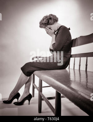 1950 s Silhouette verzweifelte Frau sitzt auf der Bank Weinen halten sich an den Händen über GESICHT TRAURIGKEIT DEPRESSION VERLUST-s 3493 HAR 001 HARS niedrigen Winkel mächtig Stimmung TRAUER PEINLICH TRAUERNDE KONZEPTIONELLE GLUM SCHEITERN MITTE NACH MITTE DER ERWACHSENEN FRAU MISERABEL SCHWARZ UND WEISS KAUKASISCHEN ETHNIE HAR 001 ALTMODISCH Stockfoto