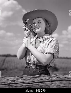 1940 LÄCHELNDE JUNGE FRAU IN Cowboy Hut und westliche Kleidung fotografieren MIT DER HAND 8MM FILM KAMERA-u 532 HAR 001 HARS HOBBY FREIZEIT INTERESSE UND BEGEISTERUNG HOBBYS WISSEN FREIZEIT HOBBY FOTOGRAFIEREN VERGNÜGEN IM LÄCHELN MIT KONZEPTIONELLEN FREUDIGE stilvolle 8-MM-HAND ENTSPANNUNG JUNGE ERWACHSENE FRAU AMATEUR SCHWARZ UND WEISS KAUKASISCHEN ETHNIE GENUSS HAR 001 ALTMODISCH Stockfoto