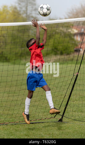 Hampshire, England, UK. April 2019. Ein junger Fußballspieler verteidigen das Ziel während eines Training Session in einem öffentlichen Park. Stockfoto