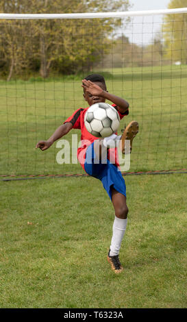 Hampshire, England, UK. April 2019. Ein junger Fußballspieler verteidigen das Ziel während eines Training Session in einem öffentlichen Park. Stockfoto