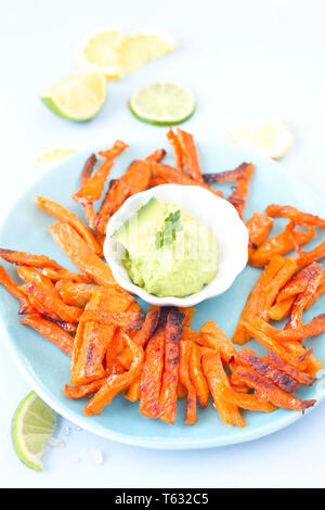 Gebackene süsse Kartoffel Pommes und Avocado dip Stockfoto