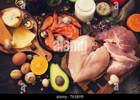 Ausgewogene Nahrung Hintergrund. Gesunde Ernährung und Diät Konzept. Protein, Lebensmittel, Obst, Säfte und Gemüse auf einem rustikalen Holzmöbeln Hintergrund. Stockfoto