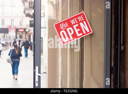 Business Zeichen, das sagt ja, wir sind offen auf der Glastür hängen. Stadt Straße Hintergrund. Stockfoto